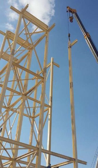 Yellow steel tower framing beside a crane