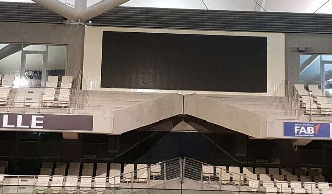 LCD screen mounted on a steel structure above grandstand seating